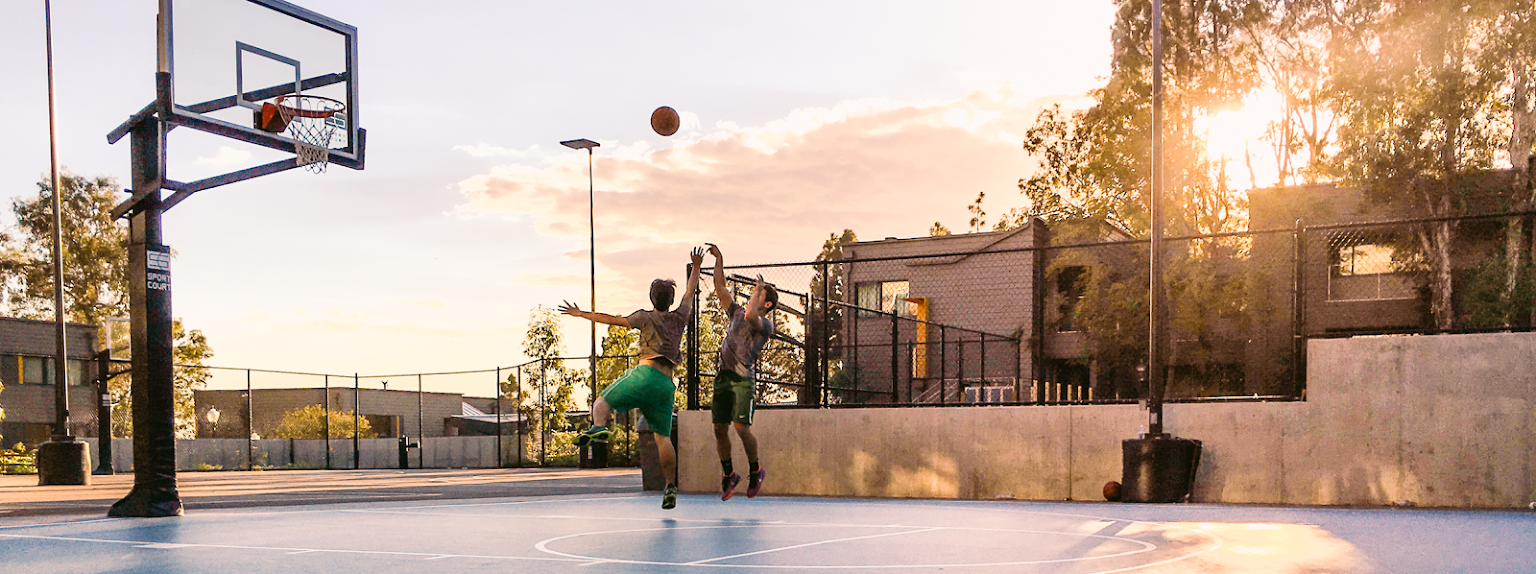 Two people playing basketball on a court