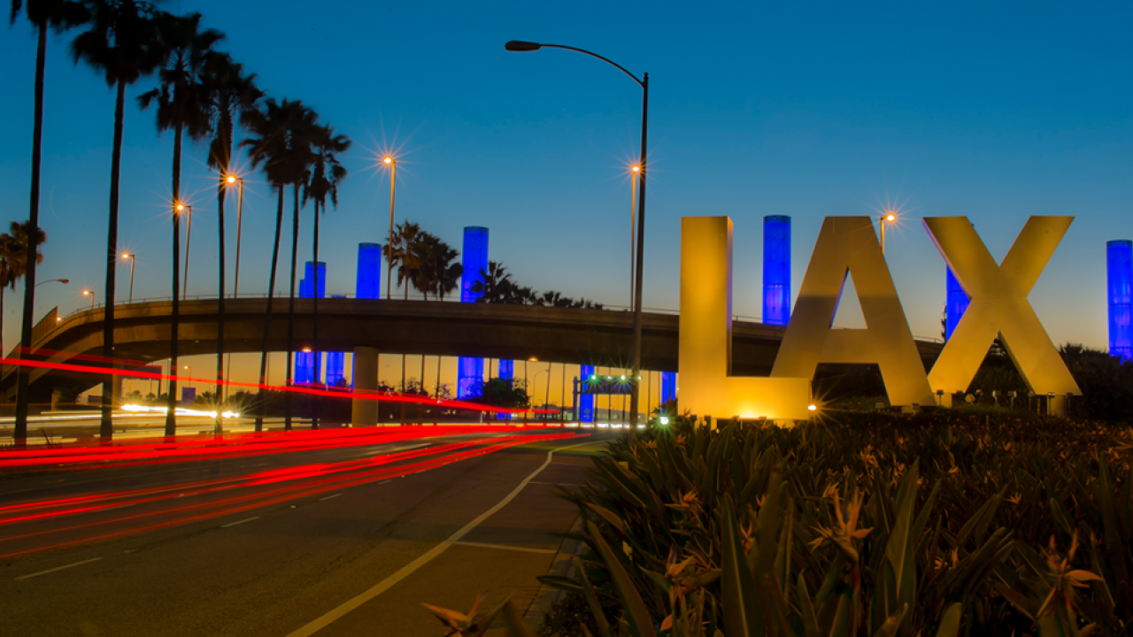 LAX at dusk with highway and palm trees in background