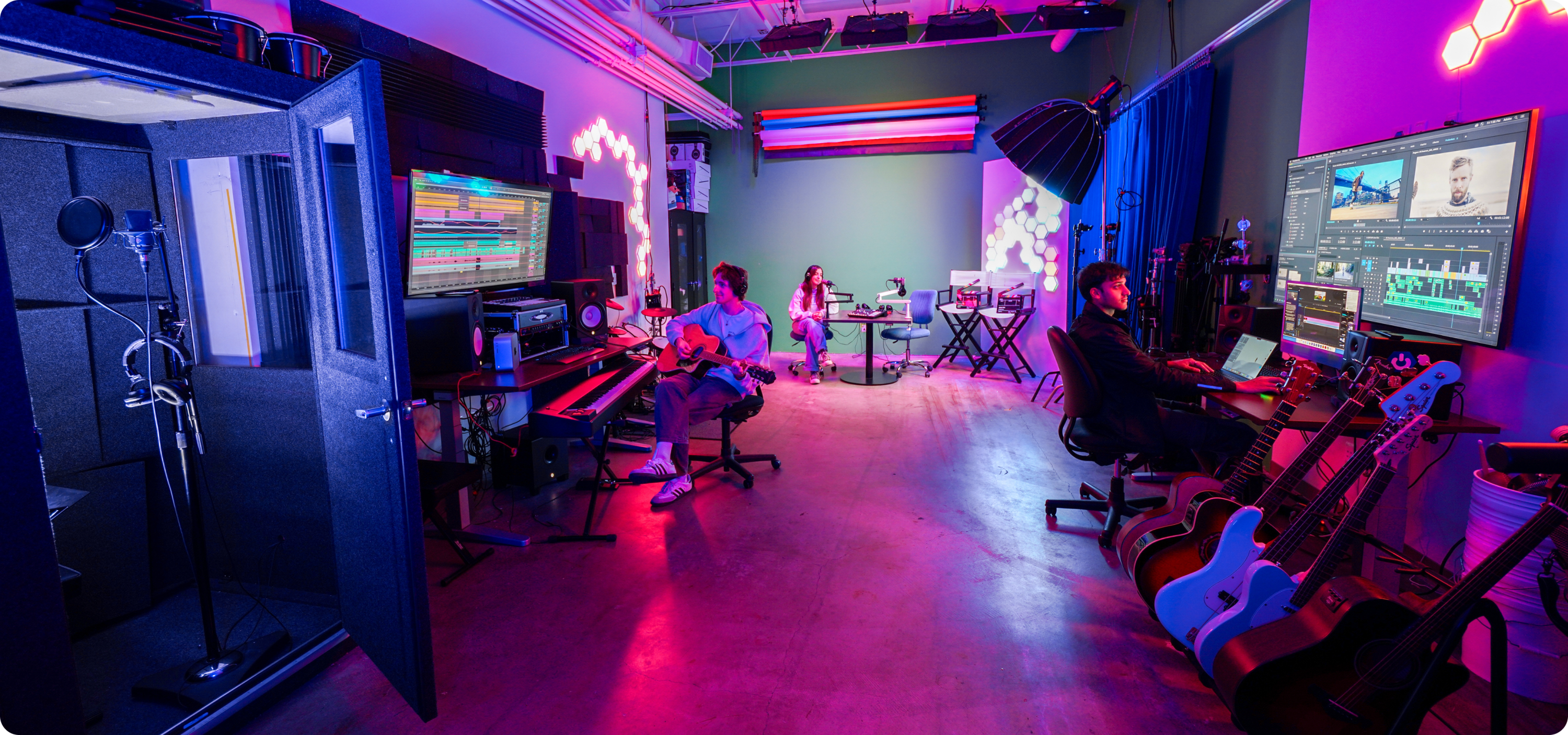 image displays learning centers studio with pink neon lights and students using the space