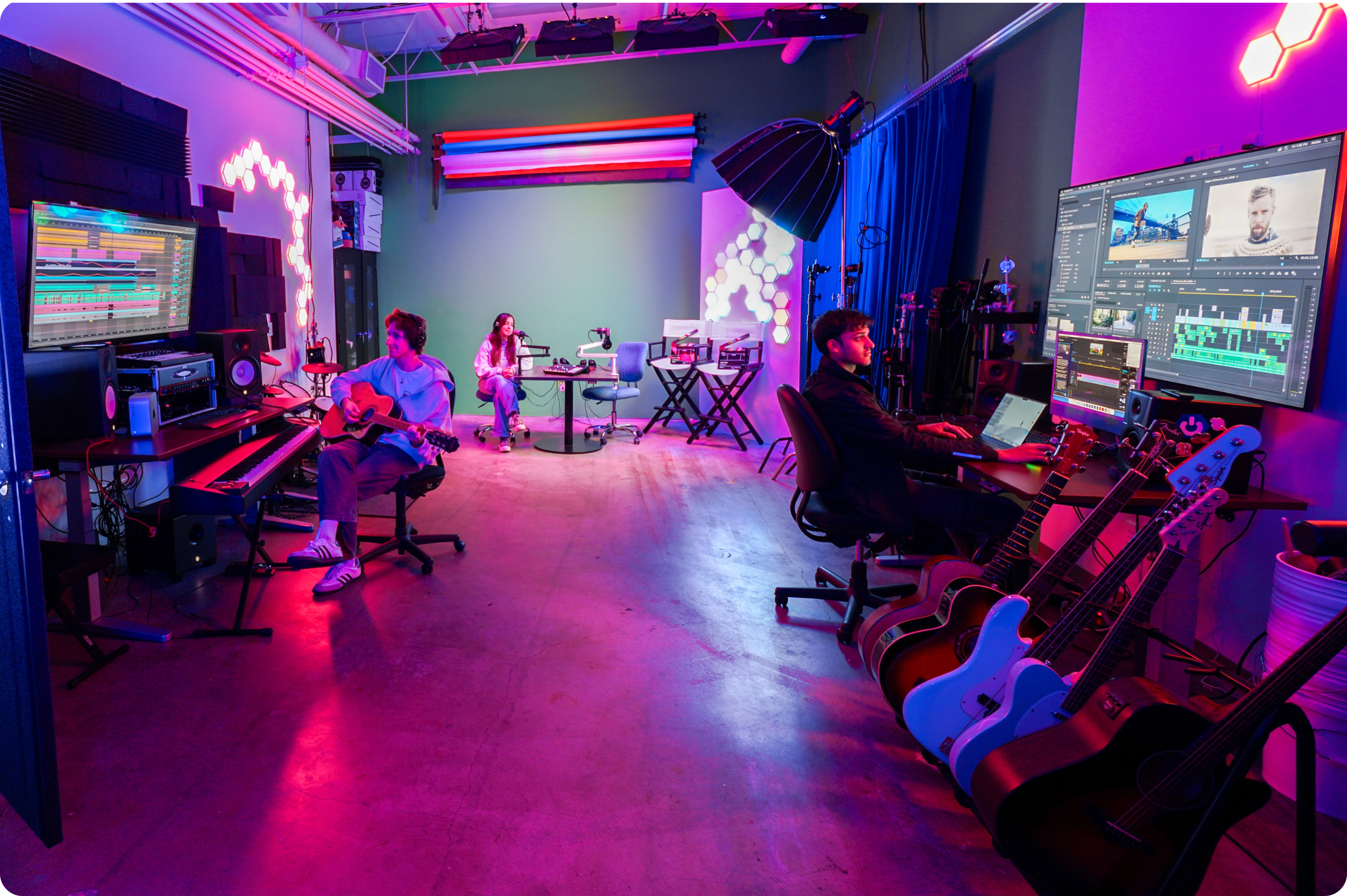 image displays learning centers studio with pink neon lights and students using the space