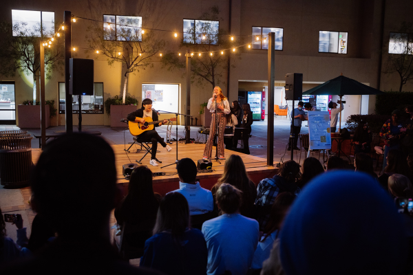 Students from Creative Collective LLC singing and playing guitar on Sunset Village stage at event