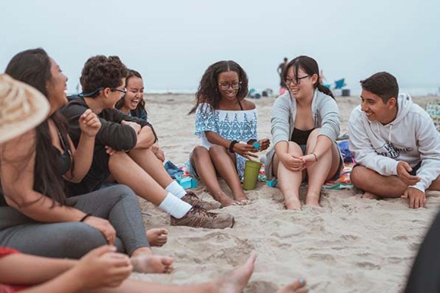 Students gathered in a circle on a beach
