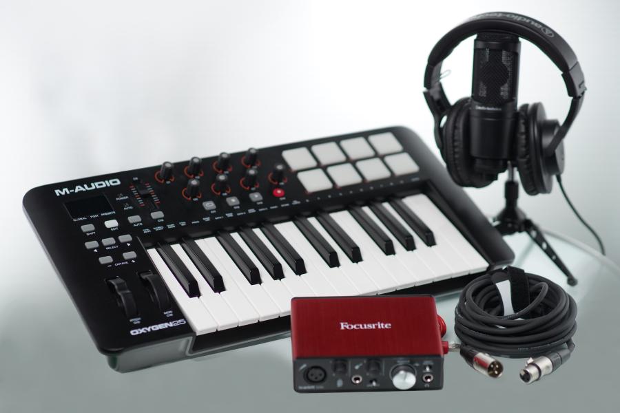 image displays a music production kit with a keyboard, audio interface, xlr cable, microphone, and headphones