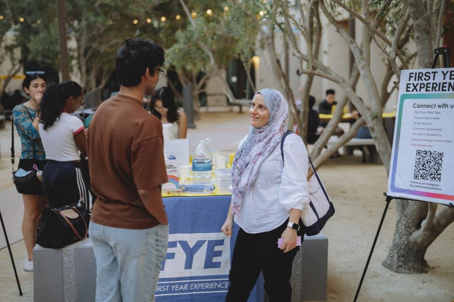 Photo od Faculty in Residence, Dr. Rana Khankan speaking to a student.